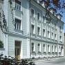 Aussenansicht, © Zauza Außenansicht eines mehrstöckigen Gebäudes mit grüner Fassade und weißen Fensterrahmen.