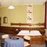 Hotelzimmer mit Doppelbett, Sofa, Tisch und Fernseher.