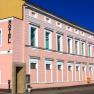 A pink building with the word 'Hotel' on the façade.