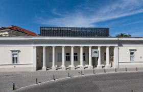 Au&szlig;enansicht des Arnulf Rainer Museums mit S&auml;ulenfassade und blauem Himmel.